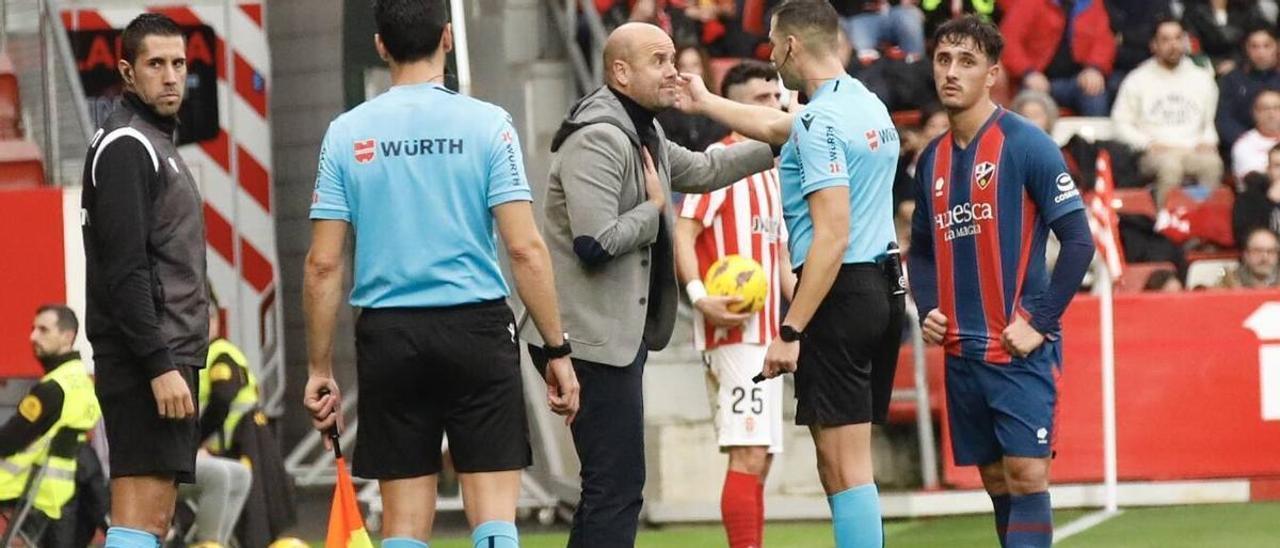 Ramírez dialoga con el árbitro Lax Franco ante Vilarrasa, con Pascanu al fondo, durante el Sporting-Huesca. | Ángel González