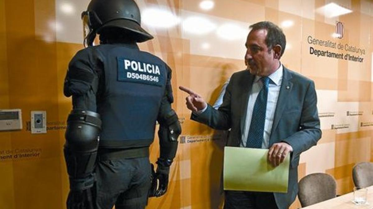 El conseller Espadaler muestra cómo irán identificados los agentes antidisturbios de los Mossos d'Esquadra, ayer, en la Conselleria d'Interior.