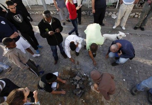 Israelis survey damage after a rocket fired from Gaza landed in the southern city of Ashdod