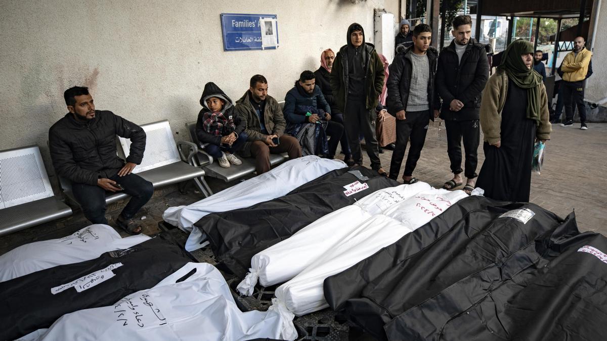 Hombres velan los cuerpos de fallecidos en un bombardeo israelí sobre Rafah.