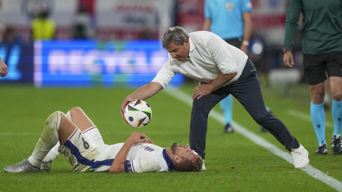塞尔维亚队主教练斯托伊科维奇将球放在凯恩的胸前，不让他浪费时间。
