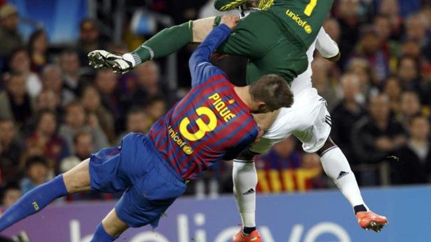 Piqué cae lesionado tras chocar con Valdés, con Drogba tapado. | albert gea / reuters