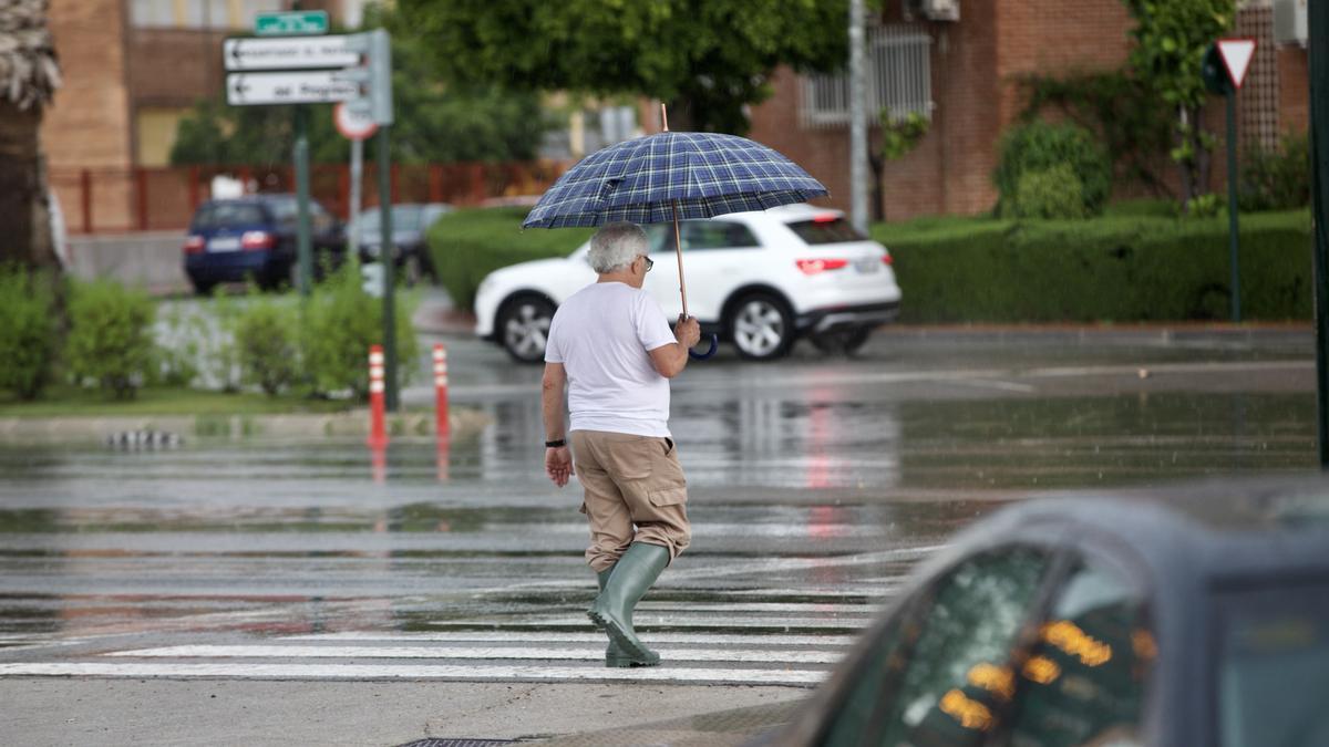 Un hombre sale a la calle tras un episodio de lluvia en Murcia.