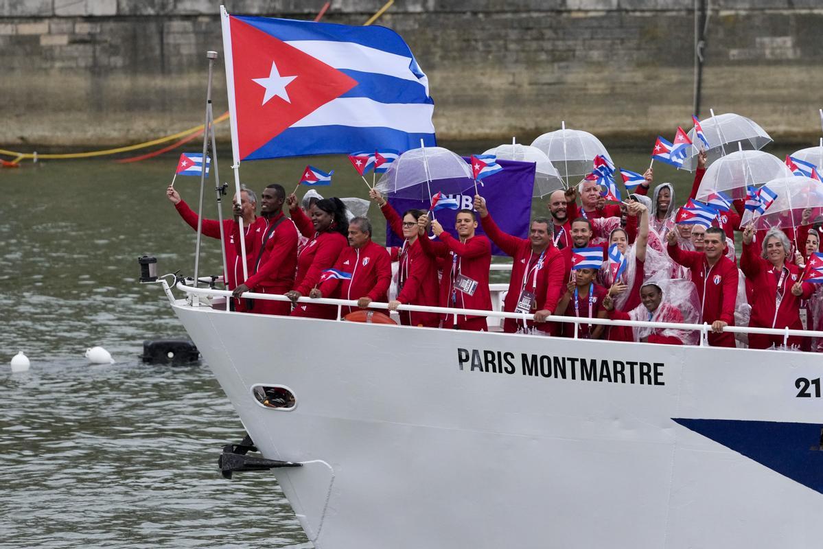 Los cubanos Julio César La Cruz Peraza e Idalys Ortiz viajan en un barco con compañeros de equipo a lo largo del río Sena en París, Francia, durante la ceremonia de apertura de los Juegos Olímpicos de Verano 2024, el viernes 26 de julio de 2024