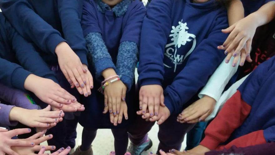 Niños y niñas con las uñas violetas en el Día de la Eliminación de la Violencia contra la Mujer.