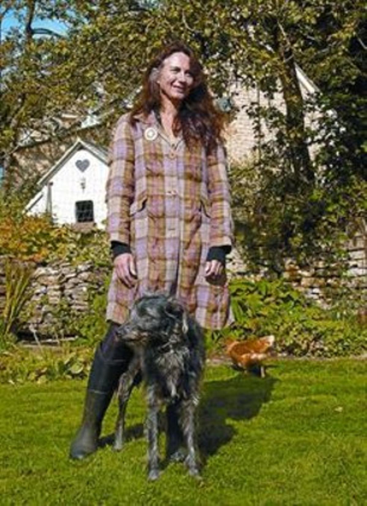 Joyce, amb un dels seus gossos i una gallina, a l’exterior de casa seva.