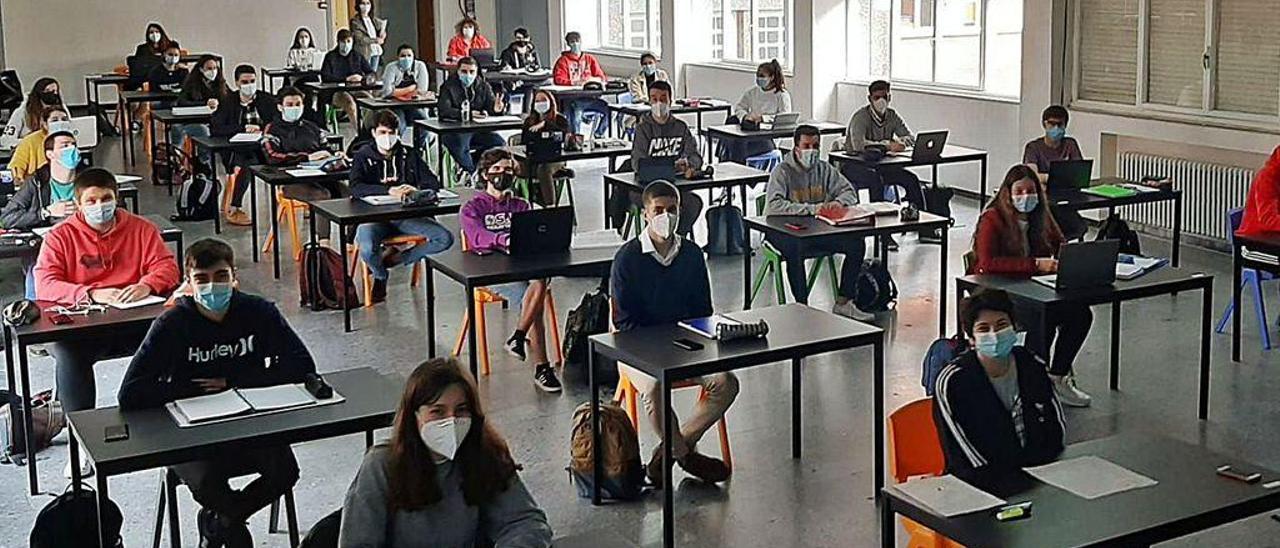 Alumnos de 2.º de Bachillerato, con mascarillas y a distancia, en una clase de Lengua de preparación para la EBAU, en el salón de actos del colegio gijonés Montedeva.