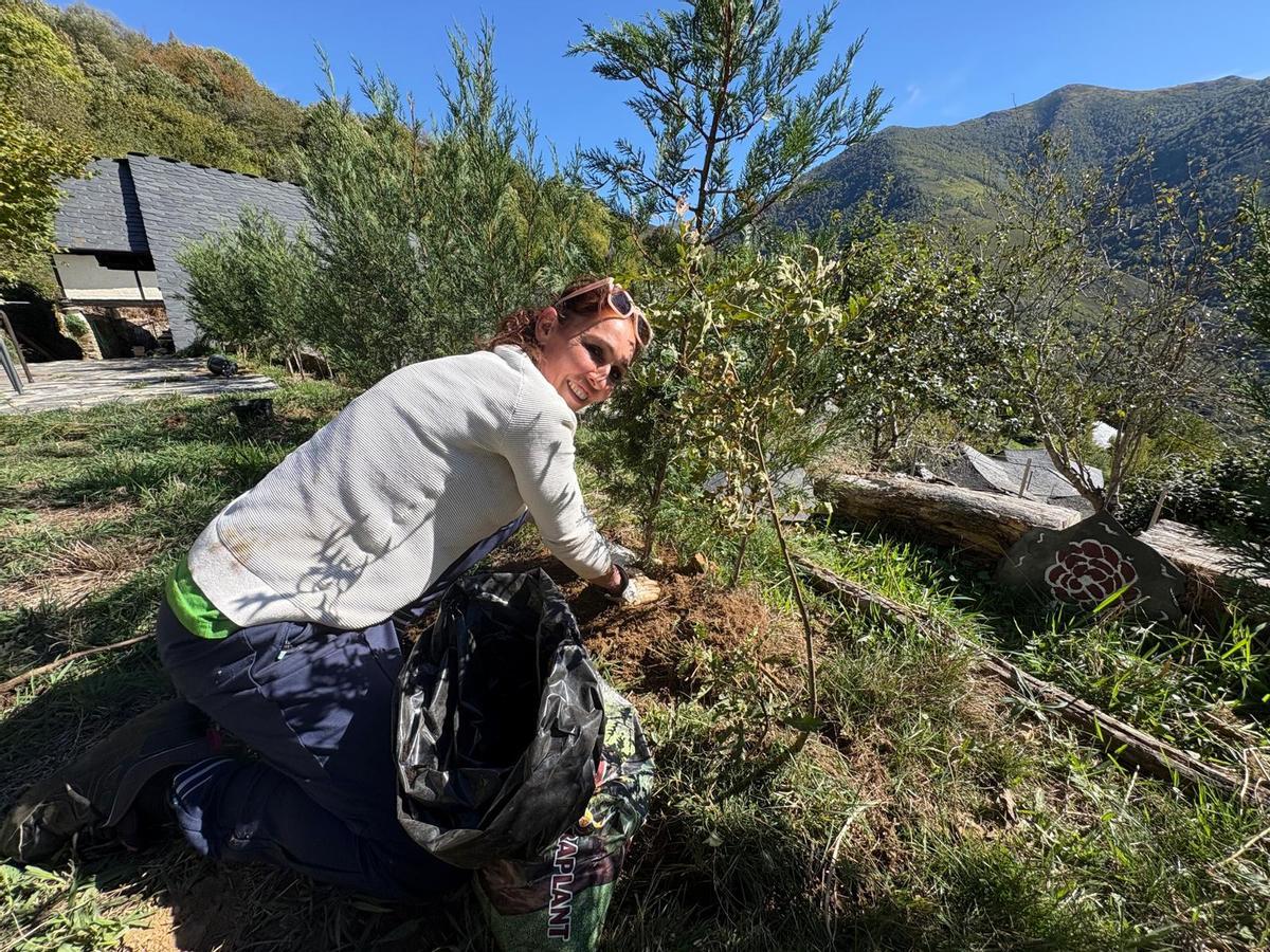 Isabel Martínez planta unos árboles en su jardín.