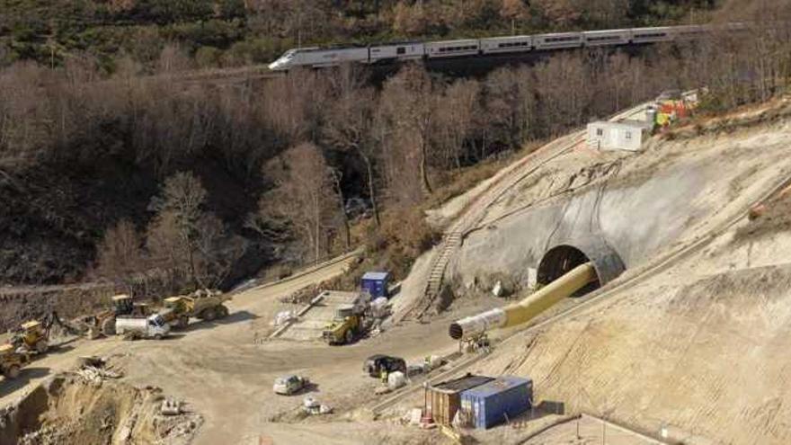 Obra de la embocadura del nuevo túnel de Padornelo, mientras por la vía convencional, que utiliza el túnel antiguo, pasa el Alvia en dirección a Zamora.