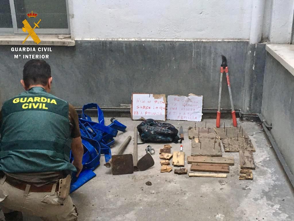 Carteles amenazantes, trampas y herramientas incautados por la Guardia Civil durante la operación.