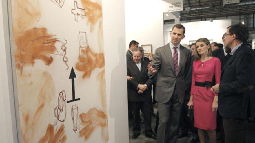 Los príncipes de Asturias contemplan, durante su visita hoy en Madrid a la feria Arco, la obra &quot;Mans i fletxa&quot; (2011) una de las últimas obras realizadas por Antoni Tàpies, que fue mostrada a los príncipes por el hijo del artista Antoni Tàpies.