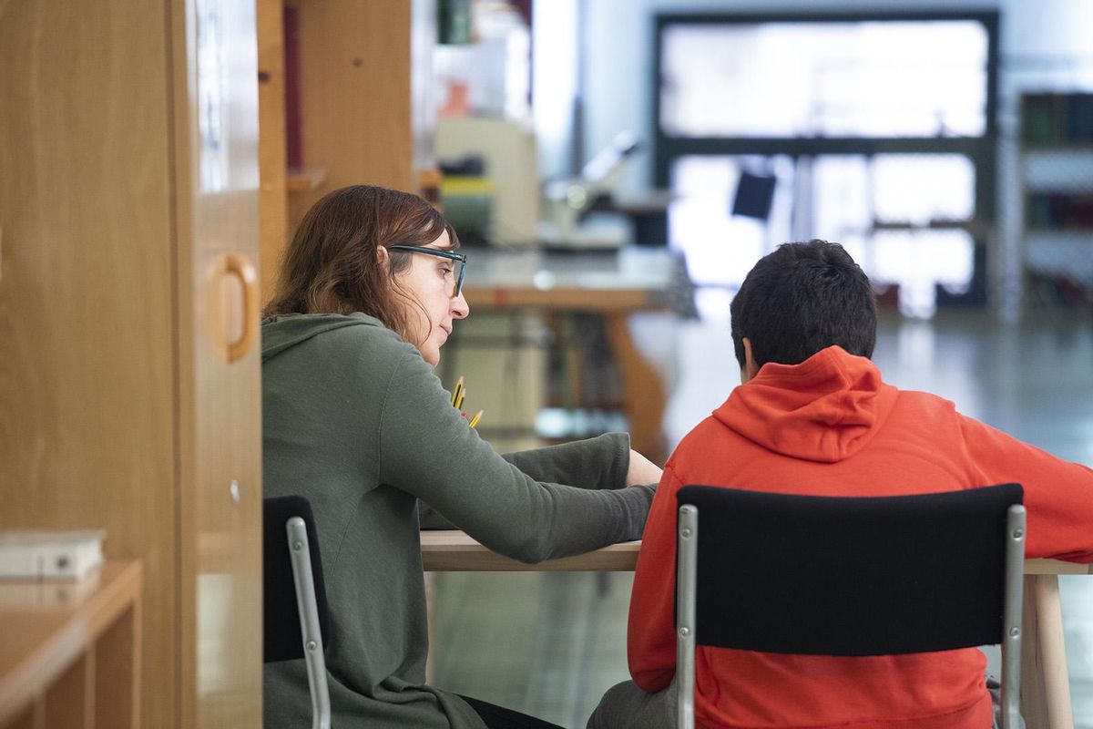 Una docente atiende a un alumno en un centro educativo Una docente atiende a un alumno en un centro educativo