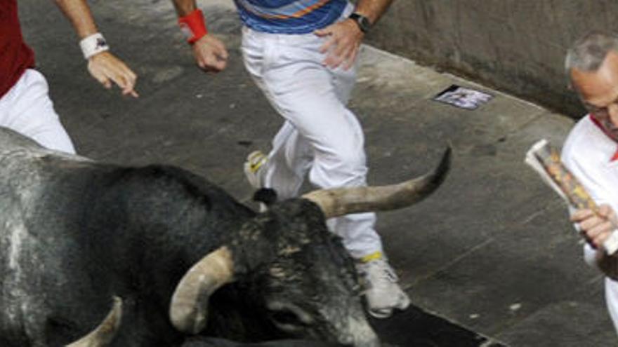 Un mozo corre ante un toro.