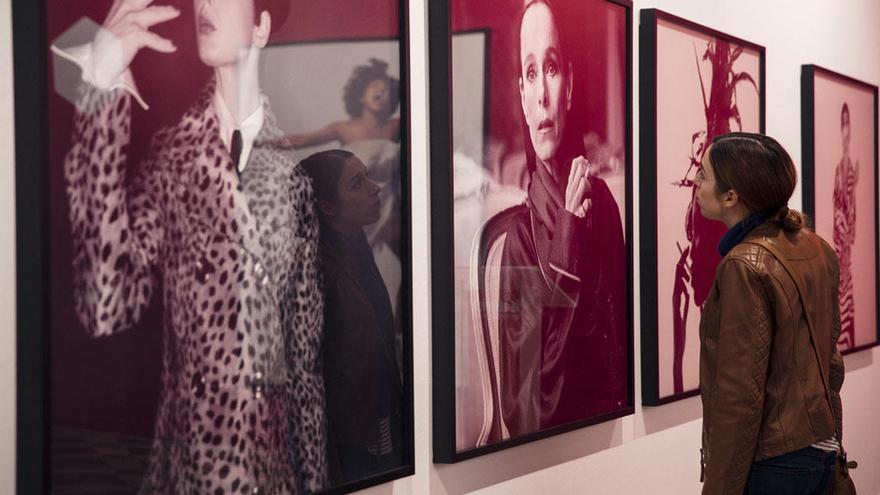 Una mujer observa el retrato de la actriz Geraldine Chaplin que forma parte de la exposición del suizo Michel Comte.