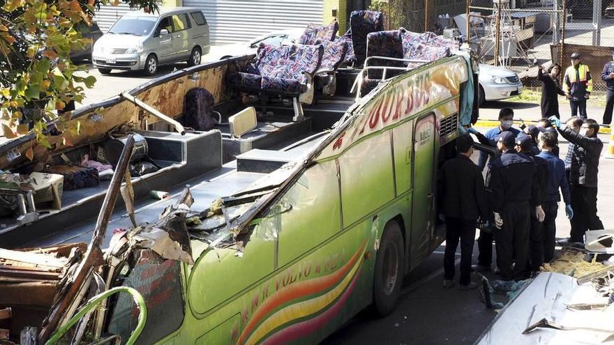 Investigadores examinan los restos del autobús siniestrado.