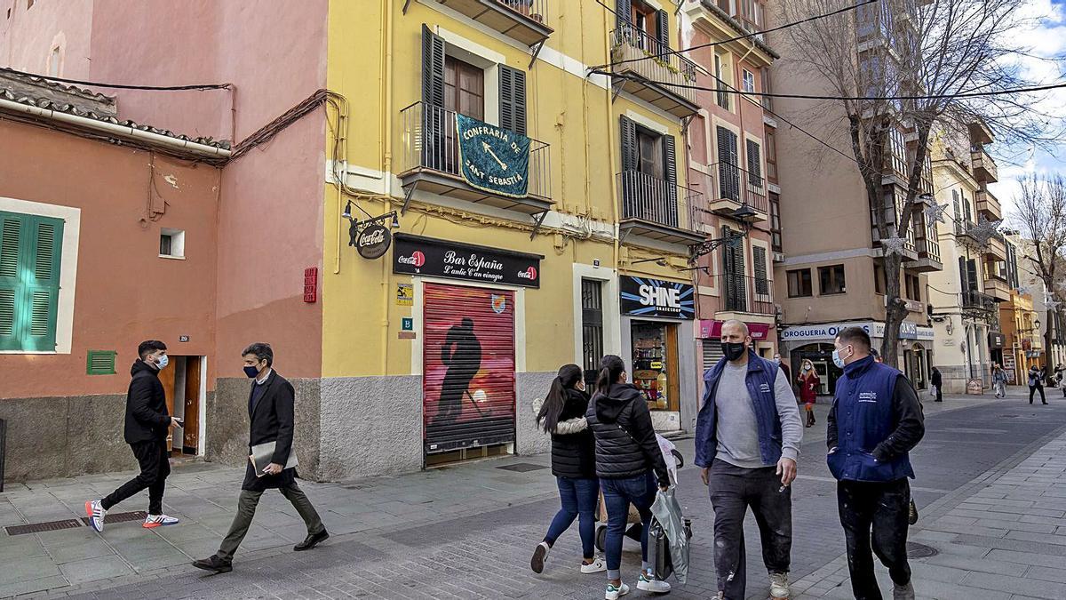 Imagen de la calle Oms al mediodía de ayer con el Bar España cerrado. Solo el pañuelo verde del balcón recordaba la fiesta.