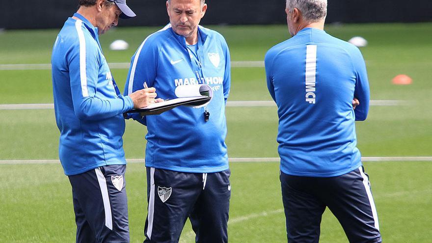 José González, entrenador del Málaga CF, toma notas antes de un entrenamiento sobre el césped de La Rosaleda junto a su cuerpo técnico.