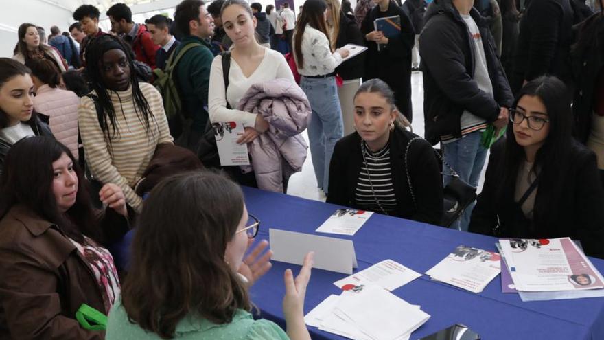 Varios estudiantes reciben información en uno de los stands empresariales de la jornada en el IES Doctor Fleming.