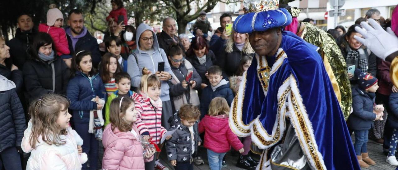 Varios niños reciben al Rey Baltasar en la entrada de la iglesia de San Nicolás de Bari, en El Coto.
