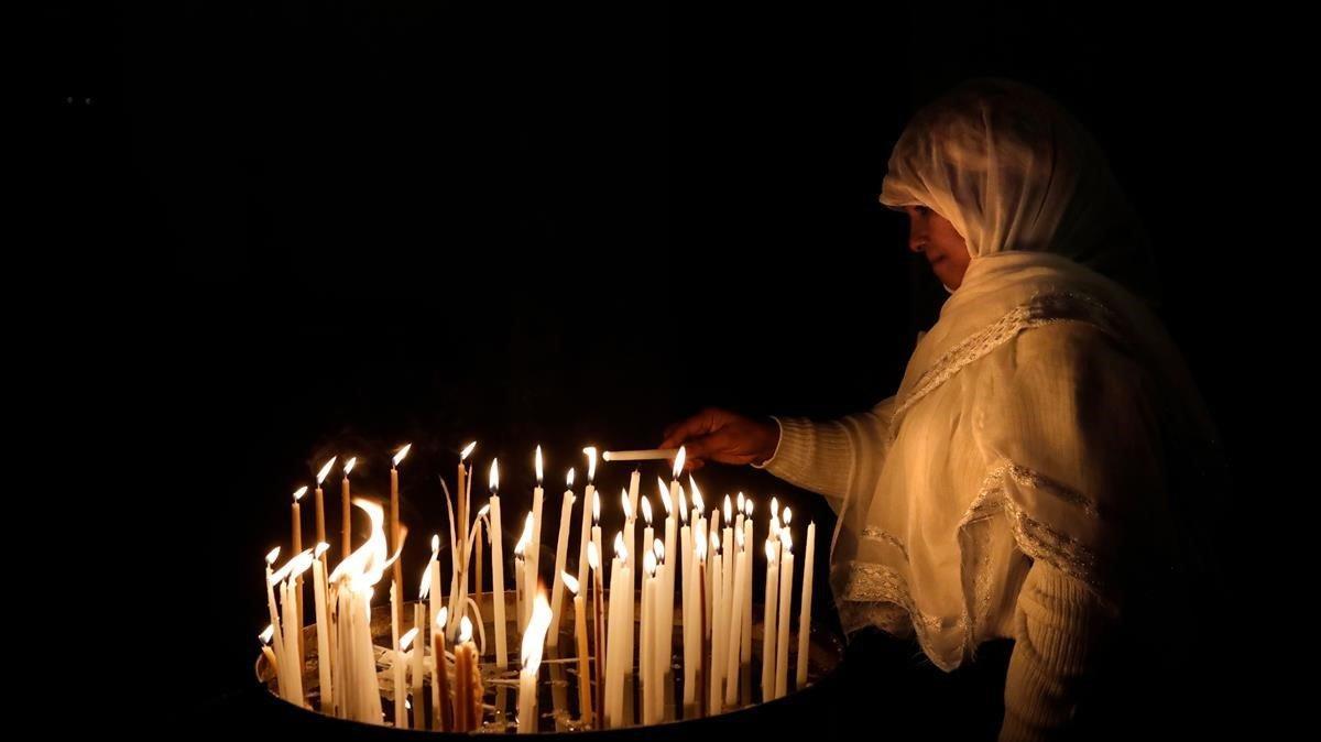 Un cristiano enciende una vela en la iglesia del Santo Sepulcro en Jerusalem