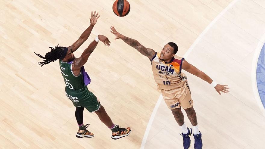 Kendrick Perry, del Unicaja Málaga, realizando un lanzamiento exterior ante la defensa de Troy Caupain durante el partido de la liga regular en el Martín Carpena.  | ACB PHOTO/M.POZO