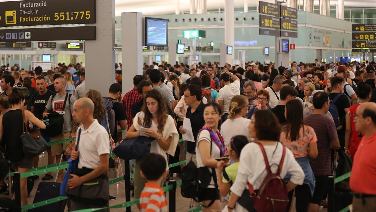 Cues per passar el control de seguretat a la T-1 de l’aeroport del Prat, aquest dijous.