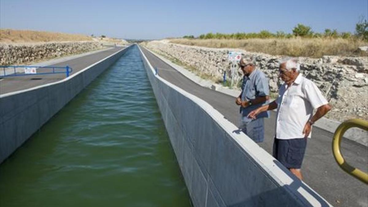 Dos vecinos de la zona contemplan el paso del agua por el Segarra-Garrigues, cerca de Les Borges, ayer.