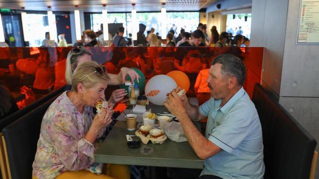 Varias personas comen en un Mcdonald's en Rusia.