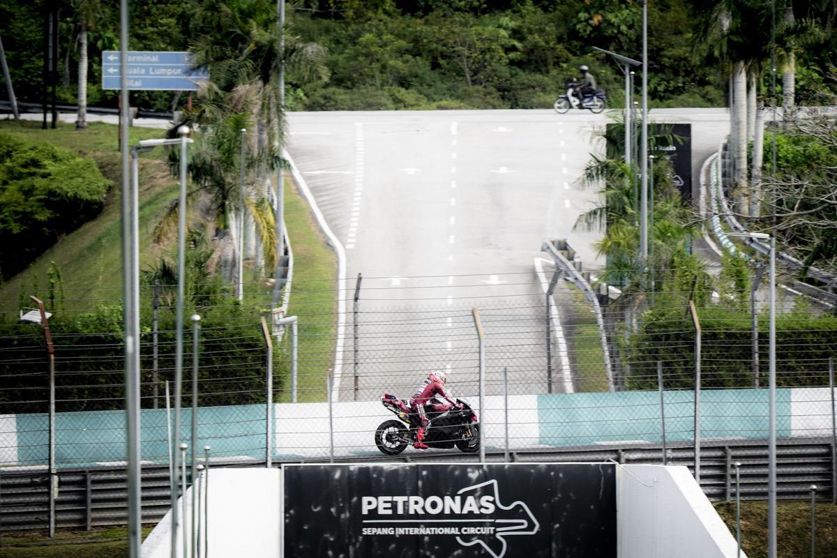 Marc Márquez pasa por encima de un puente teniendo, al fondo, la carretera que cruza Sepang.
