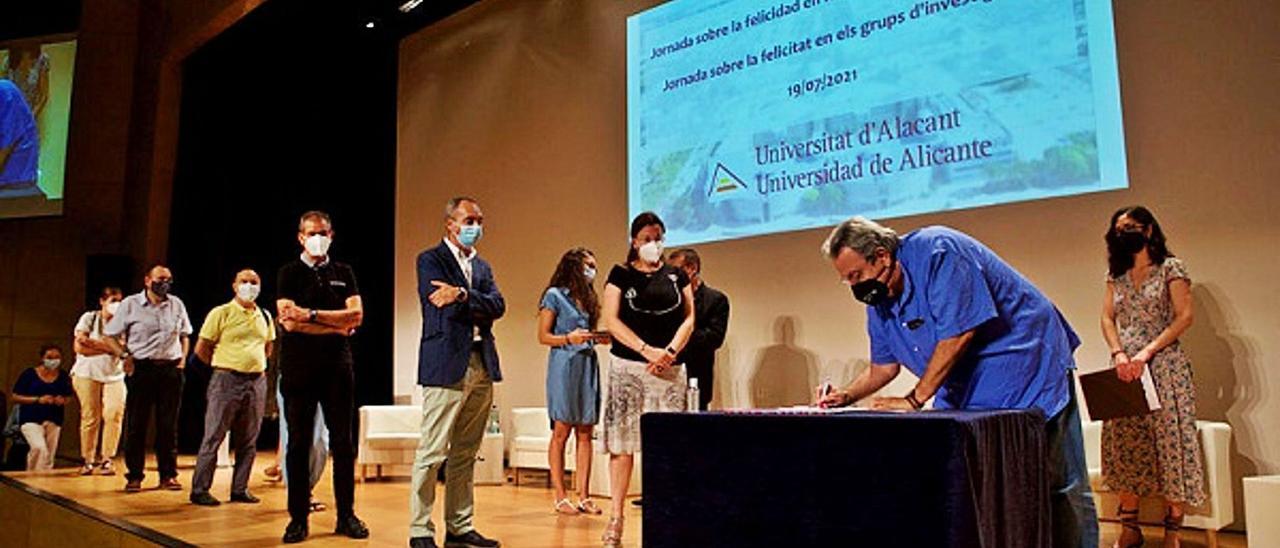 Investigadores de la UA firmando el «Decálogo para promover la felicidad en los grupos de investigación», al finalizar la jornada presidida por la rectora en el paraninfo. | INFORMACIÓN