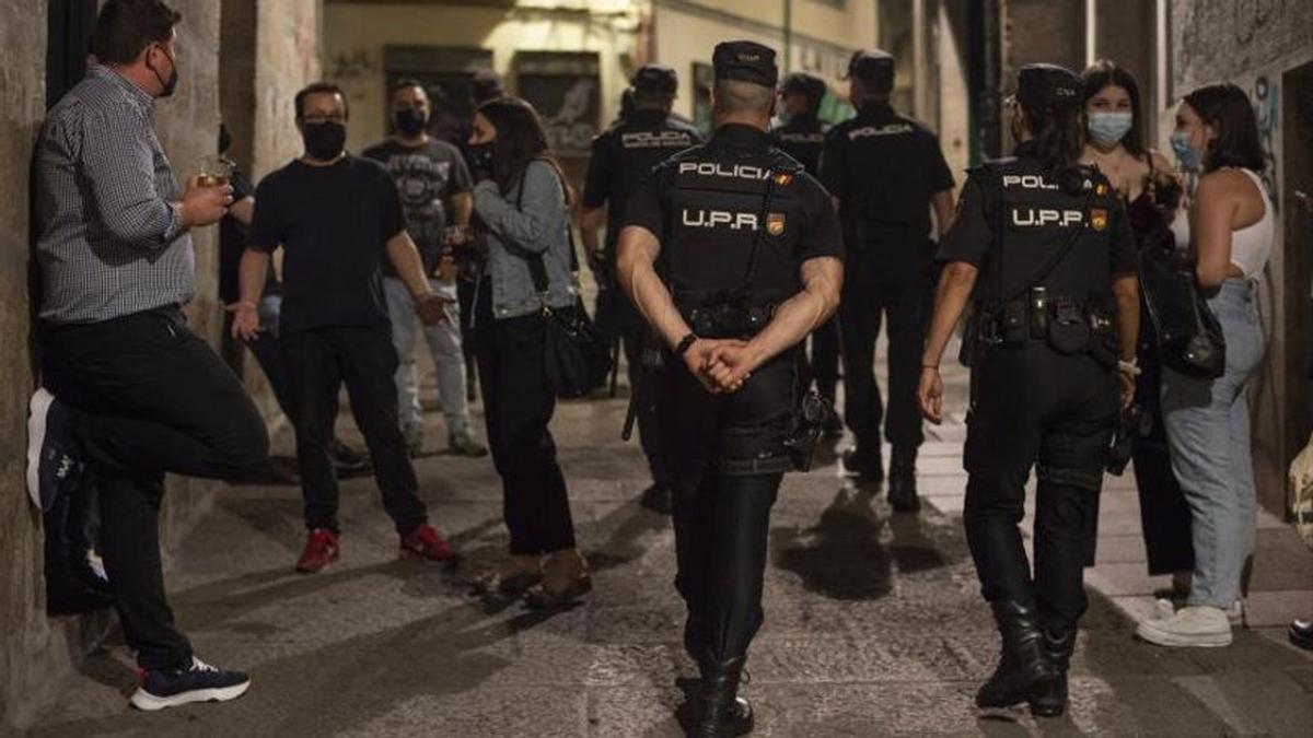 Policías controlan el ocio nocturno en la calle en Ourense, este verano.