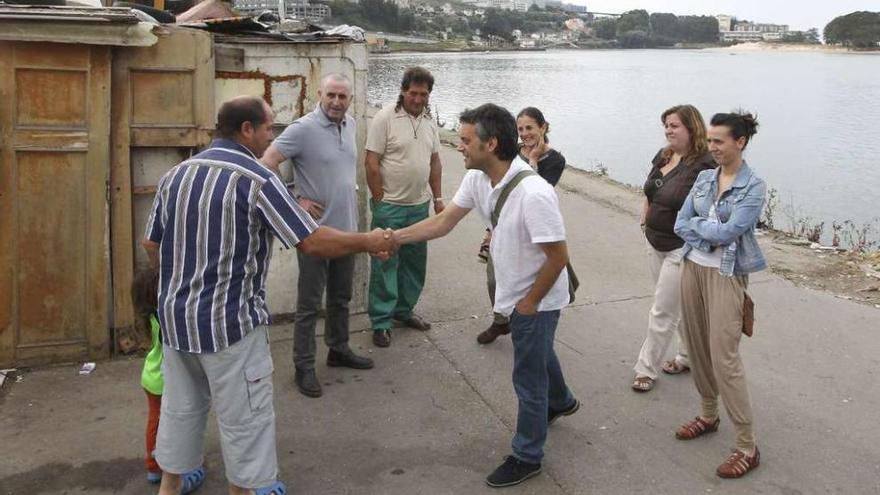 El alcalde, Xulio Ferreiro, saluda a uno de los habitantes del poblado chabolista de A Pasaxe.