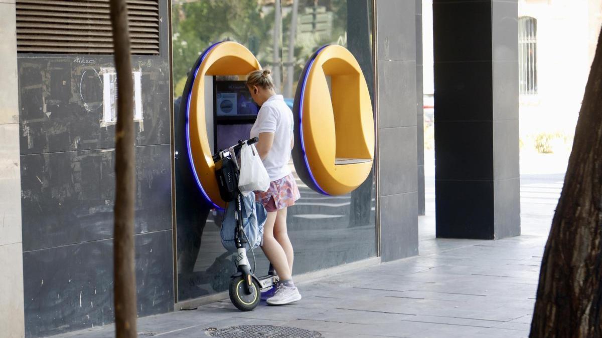 Una mujer consultando su cuenta bancaria en un cajero automático del centro de Murcia, esta semana.