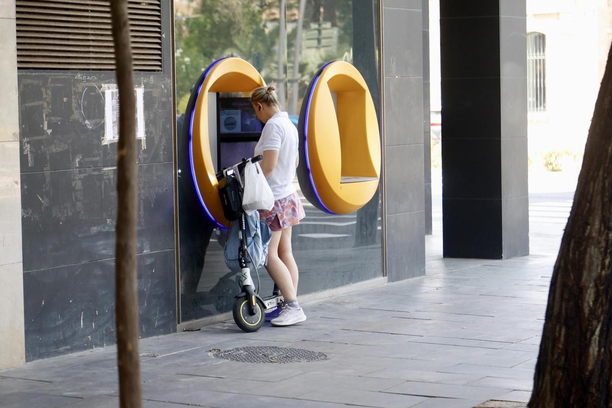 Una mujer consultando su cuenta bancaria en un cajero automático del centro de Murcia, esta semana.