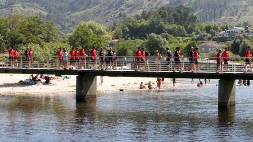 Los jugadores del Sporting pasean sobre uno de los puentes del río Vez.