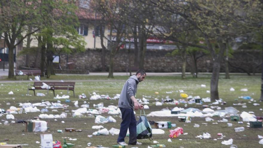 Una persona realiza labores de recogida de restos en el parque de Ferrera tras la Comida en la Calle.