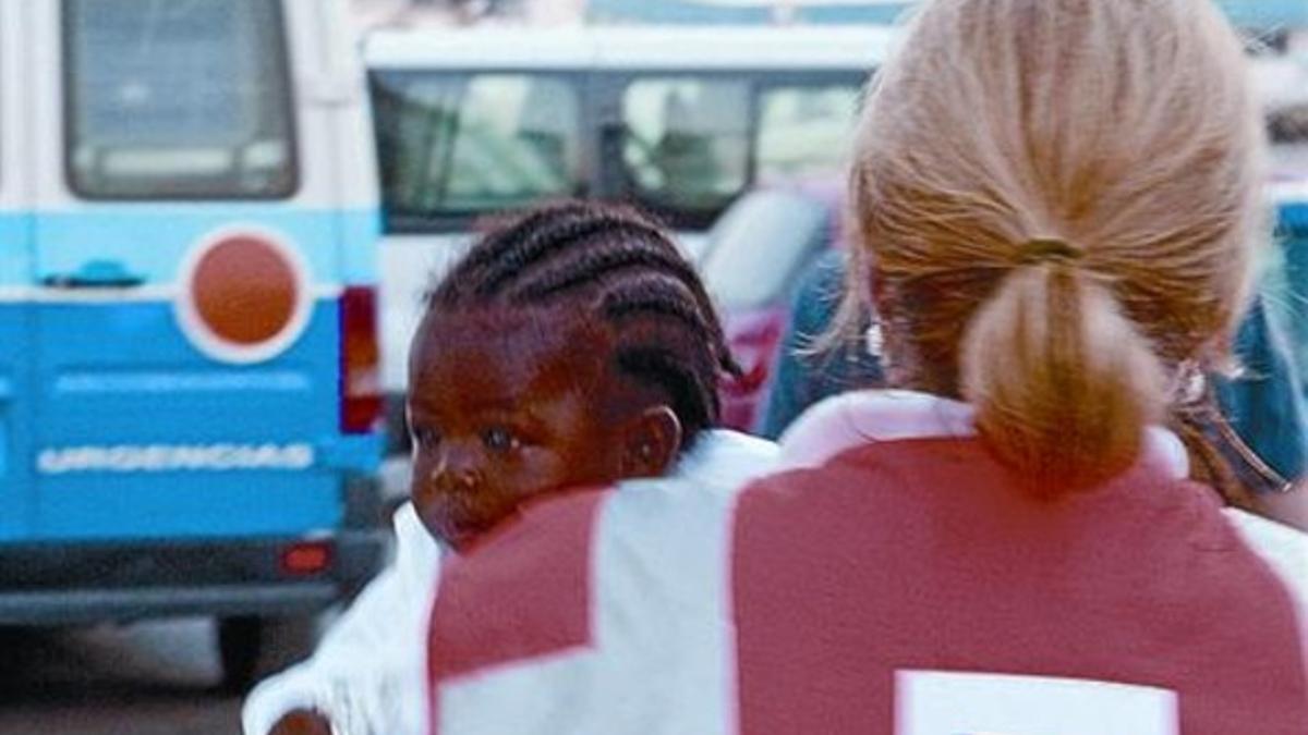 Una miembro de la Cruz Roja se dispone a evacuar a un bebé al hospital.