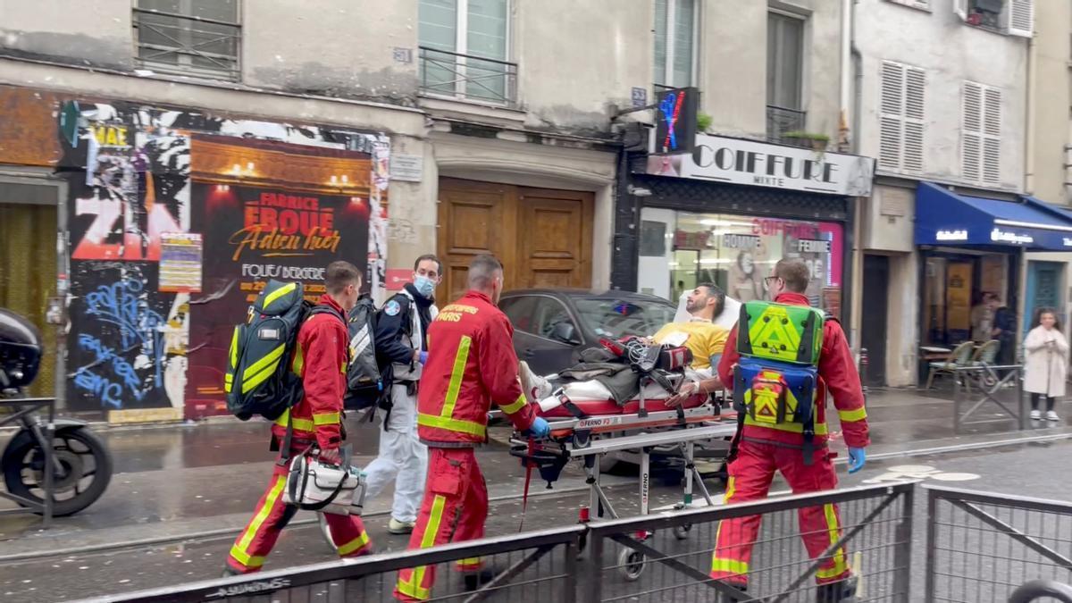 Bomberos trasladan en una camilla a uno de los heridos en el tiroteo de este viernes en París.
