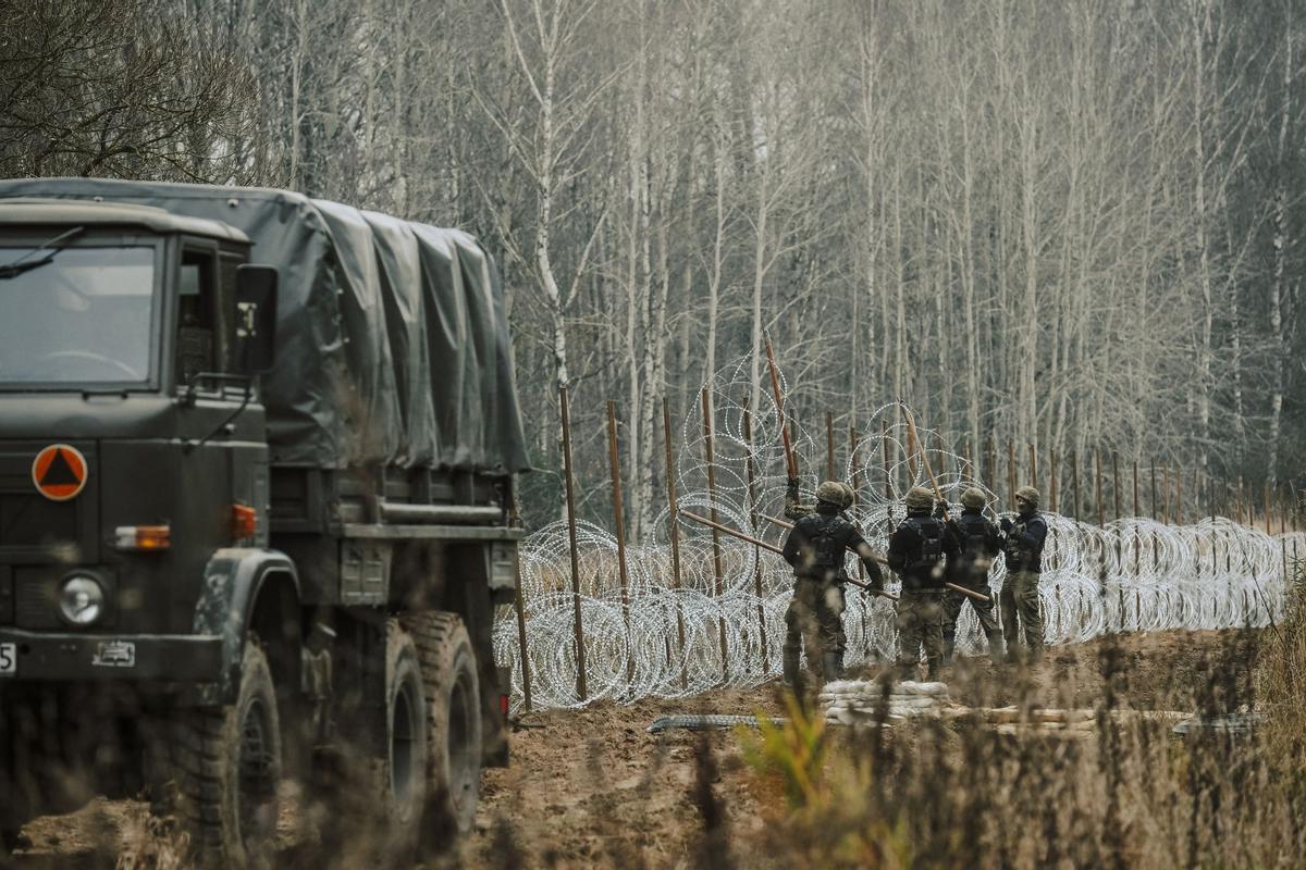 Soldados del ejército polaco arreglan bobinas de alambre de púas en una valla a lo largo de la frontera polaca, con el enclave ruso de Kaliningrado, cerca de Zerdziny, Polonia