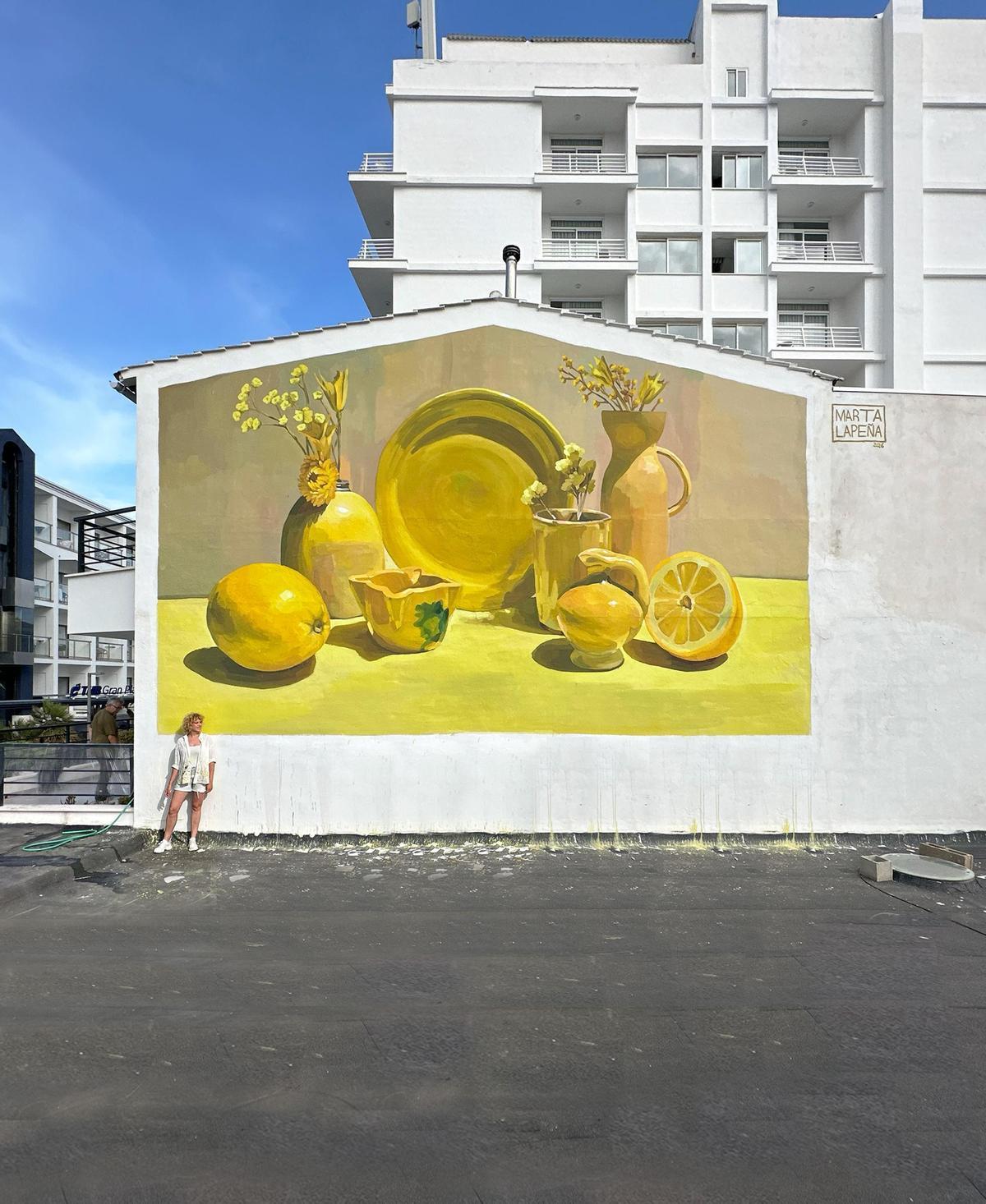 Marta Lapeña junto a su mural en Can Picafort, Mallorca.