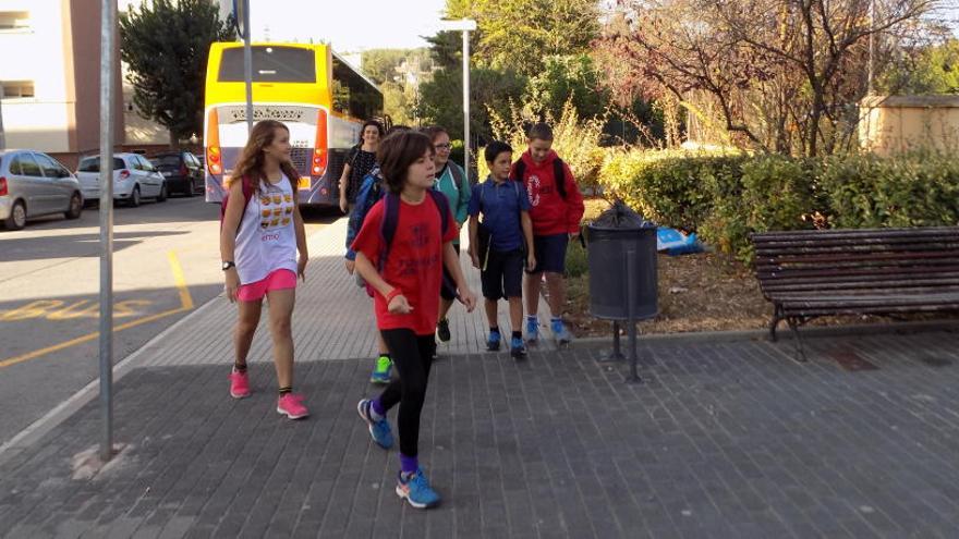 Alumnes baixant del bus, a punt per començar les classes.