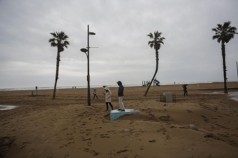 Temporal de lluvia: las mejores imágenes del paseo marítimo de València cubierto de arena