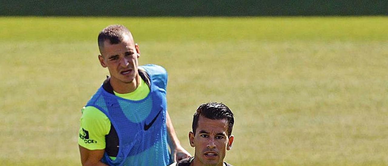 Luis Hernández, en primer término, observa la trayectoria del balón.