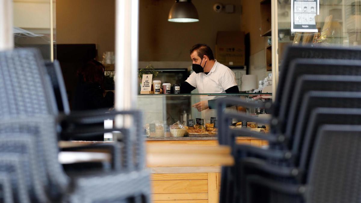 Un camarero prepara cafés para llevar (único formato permitido) el día en el que toda la hostelería comienza la primer jornada de cierre total cumpliendo las nuevas restricciones aprobadas por la Generalitat