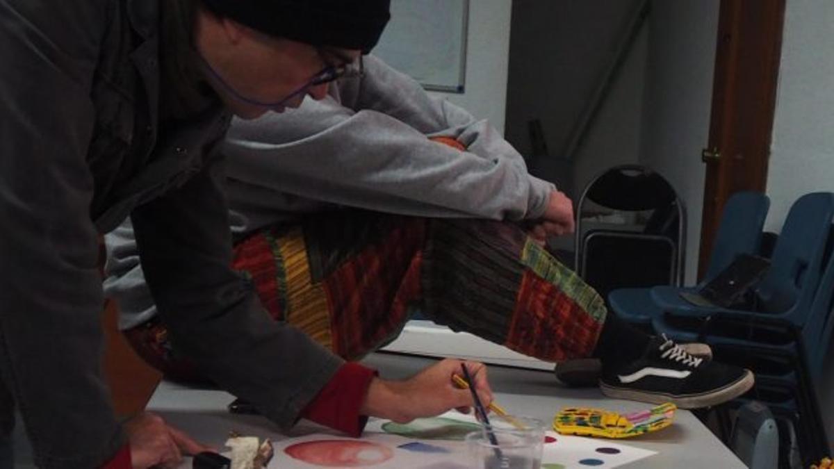 Un voluntario en un taller de pintura de Málaga Acoge
