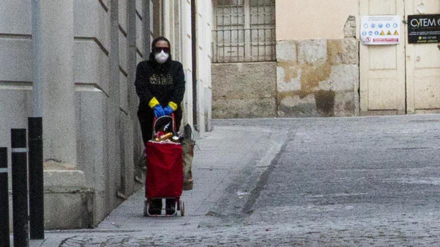 Una mujer vuelve a casa con la compra en Alicante.