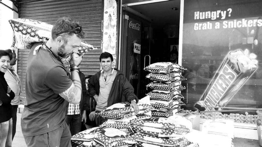 Alberto Rojo, ayer acompañado por nepalíes, recoge uno de los sacos de comida que llevaron a Rasuwa.