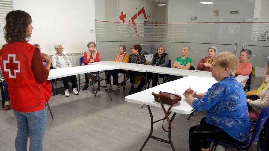 La psicóloga, de pie, conversa con las participantes en la iniciativa, en Cruz Roja Benavente. | E. P.