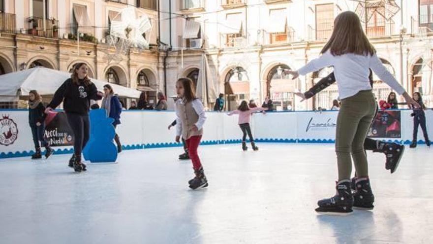 Los primeros niños y niñas disfrutando de la pista de hielo en la Plaça de Dins.