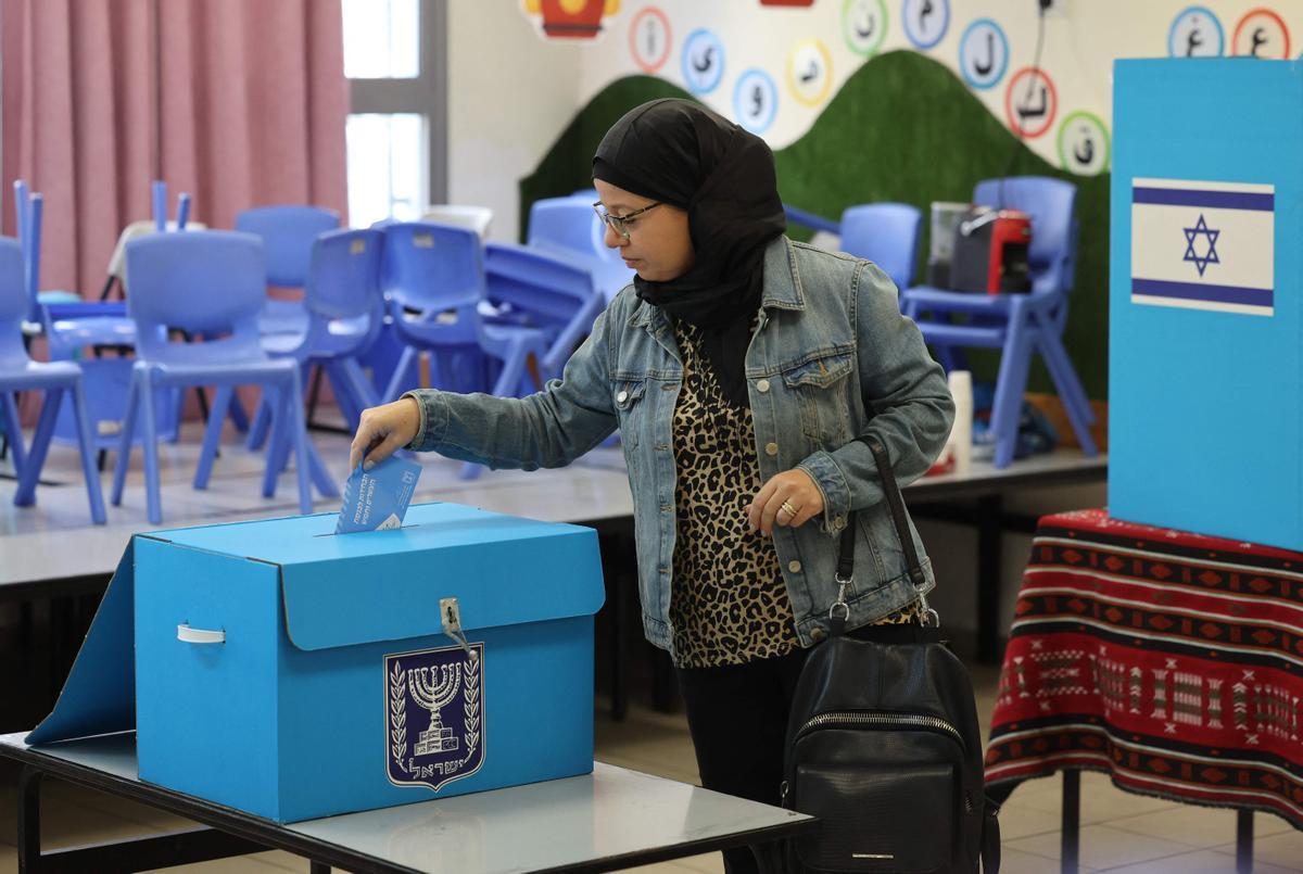 Una votante árabe-israelí emite su voto en un colegio electoral en la ciudad predominantemente árabe de Taybeh, en el centro de Israel, durante las elecciones nacionales de Israel.